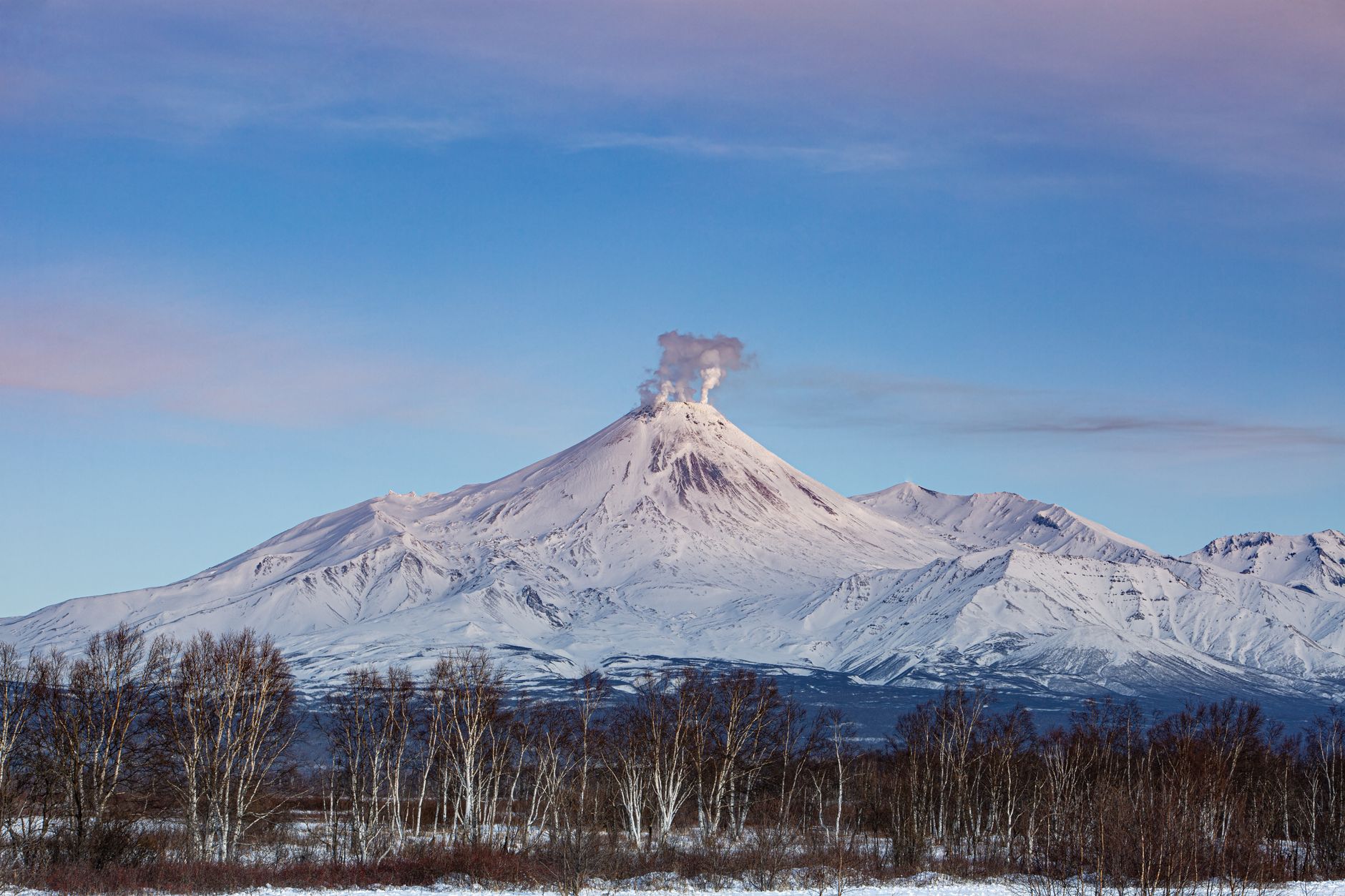 南极洲埃里伯斯火山口上方飘出烟雾，背景是冰雪。