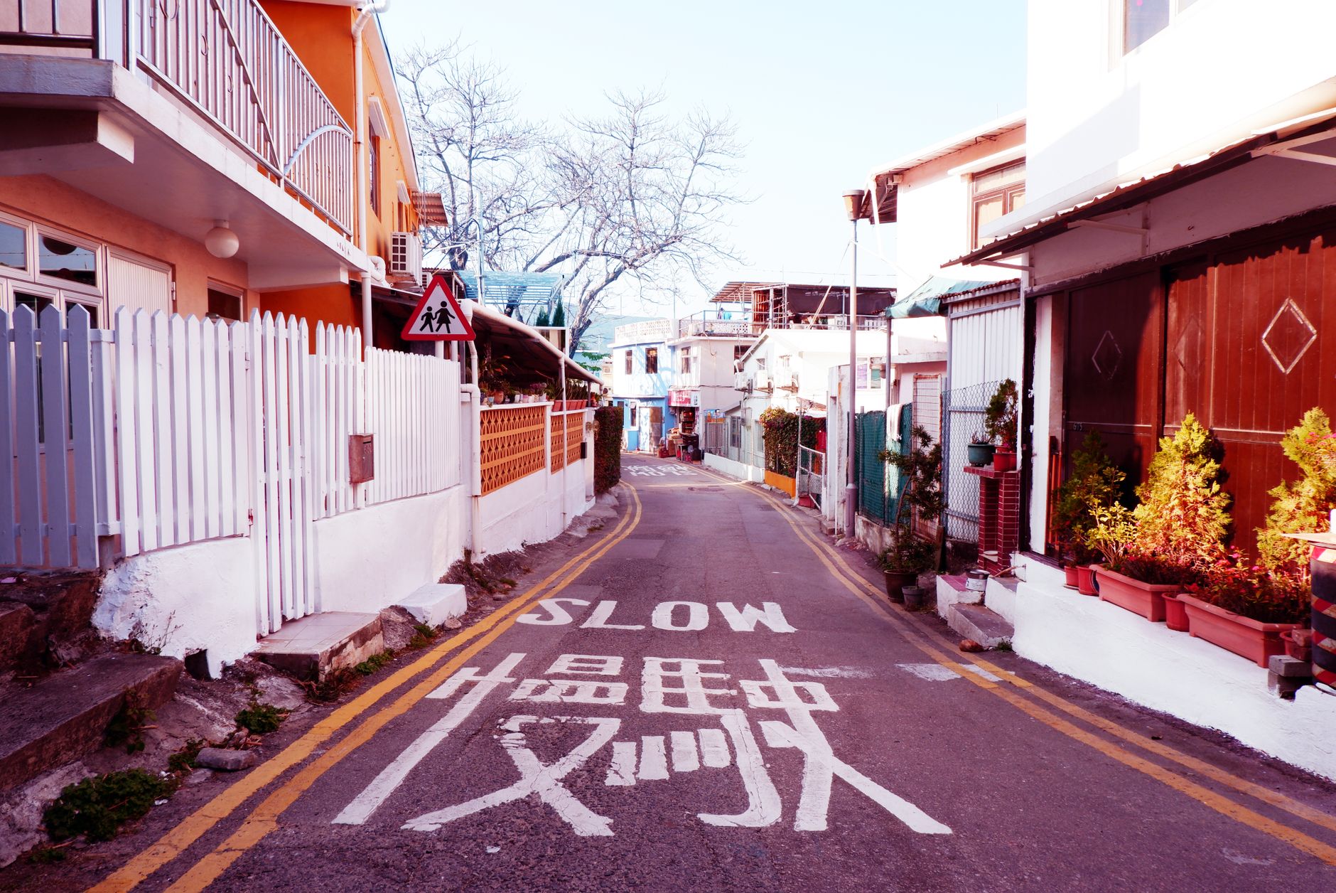 一张黄色菱形路牌，中间写有黑色的汉字“慢”